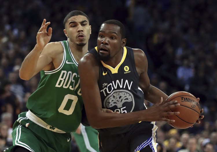 Golden State's Kevin Durant, right, drives against Boston's Jayson Tatum during the Warriors' 109-105 win Saturday in Oakland, California.