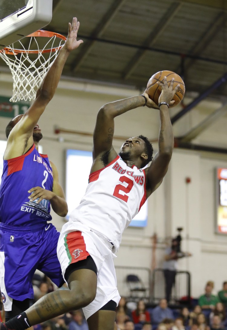 Maine's L.J. Peak shoots over Long Island's Akil Mitchell in the first quarter the Red Claws' 109-100 win Sunday at the Portland Expos.