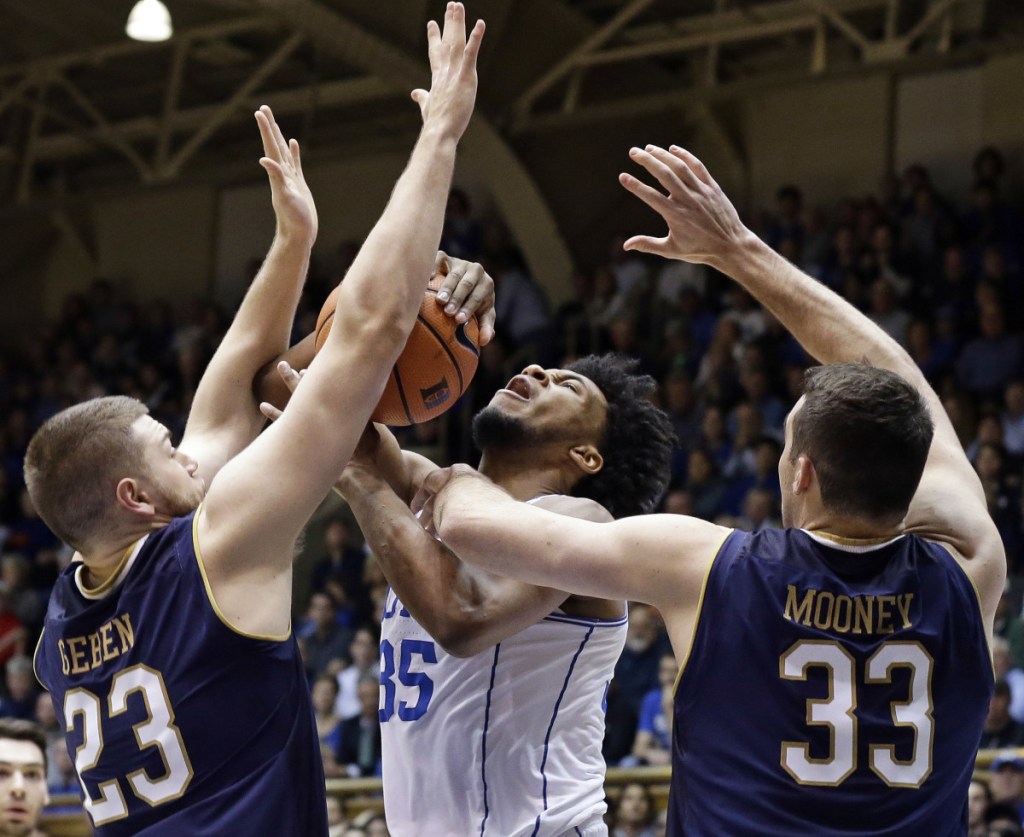 Duke's Marvin Bagley III takes a shot while being defended by Notre Dame's Martinas Geben, left, and John Mooney during the Blue Devils' 88-66 win Monday in Durham, N.C.