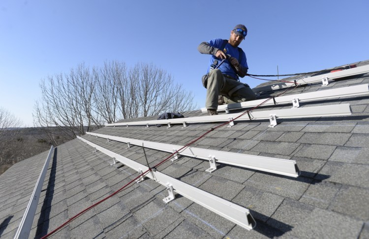 Zach Good of ReVision Energy prepares a roof for solar panels at a home in Cape Elizabeth in 2015. L.D. 1686 would help Mainers from being excessively taxed on the solar power they produce.