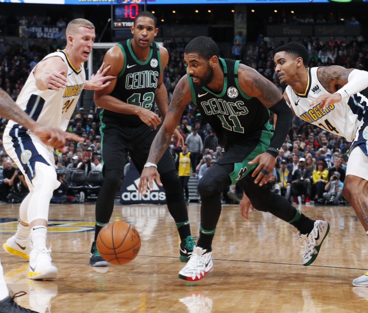 Boston's Kyrie Irving, third from left, drives against Denver's Mason Plumlee, left, and Gary Harris as teammate Al Hoford looks on during Monday's game, a 111-110 win for the Celtics.