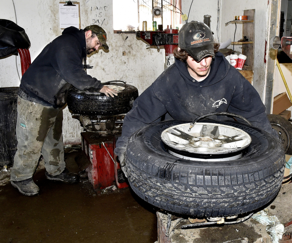 Waterville Tire Warehouse employees Jason Dumais, left, and Lane LeBlanc change tires Tuesday at the company store in Waterville. LeBlanc said their work has been nonstop because the cold weather is causing tires to deflate, and people are installing snow tires.