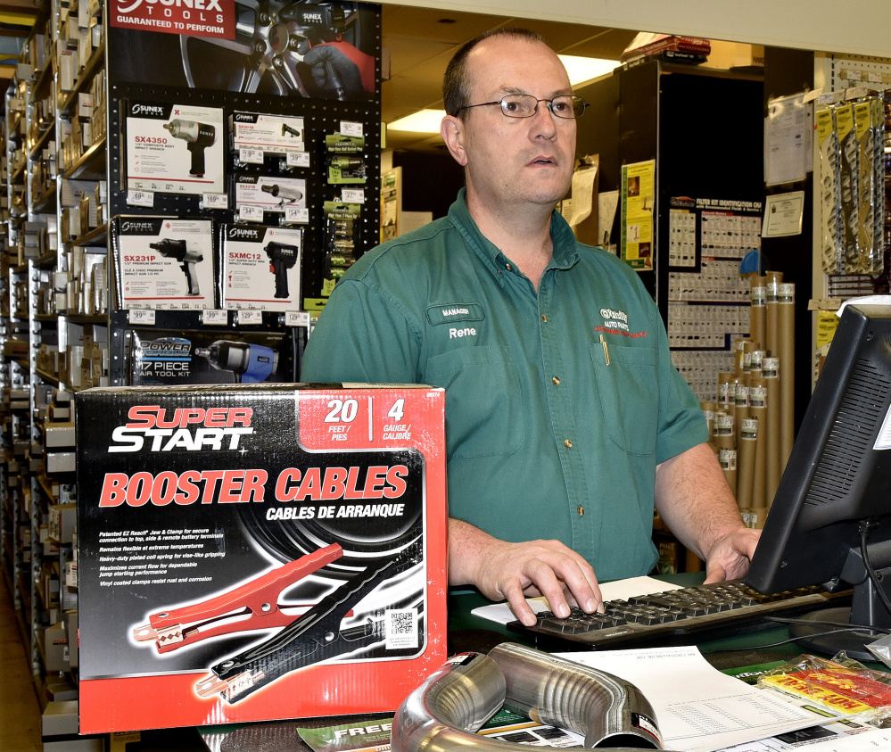 O'Reilly Auto Parts store manager Rene Huard waits on a customer purchasing battery booster cables Tuesday at the Waterville store. Huard said the store has sold 70 batteries since the weekend and a truckload is arriving this week.