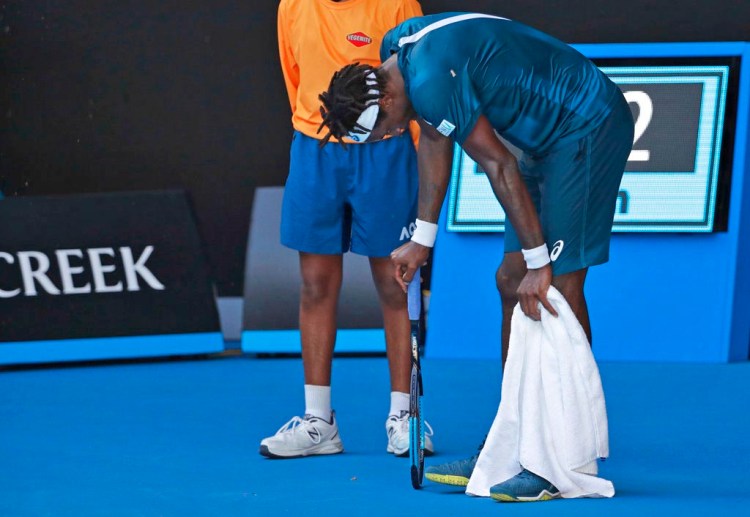 France's Gael Monfils rests during a match against Serbia's Novak Djokovic in the second round Thursday at the Australian Open in Melbourne. The heat peaked during Djokovic's 4-6, 6-3, 6-1, 6-3 win over Monfils. Both players slouched in the shade between points, earning warnings about time delays from the chair umpire.