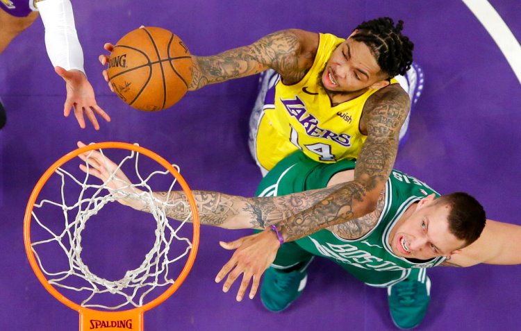 Lakers forward Brandon Ingram and Celtics forward Daniel Theis reach for a rebound during the first half of Tuesday night's game in Los Angeles.