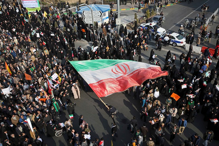 In this photo provided by Tasnim News Agency, a demonstrator waves a huge Iranian flag during a pro-government rally in the northeastern city of Mashhad, Iran on Thursday.