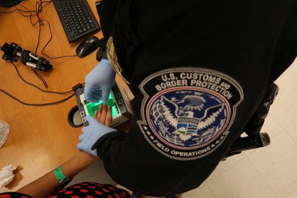 A Border Patrol officer takes an asylum seeker's fingerprints in McAllen, Texas, last May. A letter writer says a bus passenger is over-reacting to a question he was asked by Border Patrol agents.