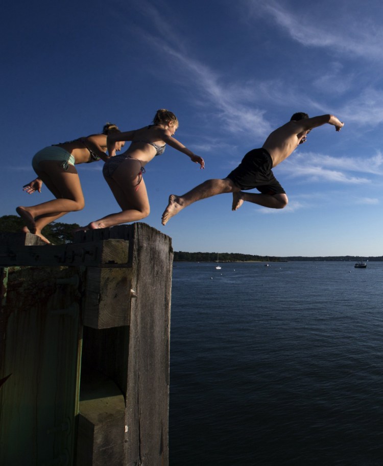 Young swimmers leap from the Peaks Island dock pilings last July 26 shortly after the departure of the 6 p.m. ferry. Kids are spending more time online and less time outdoors, to their detriment.