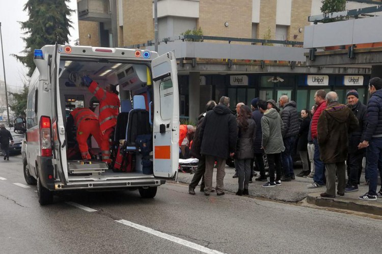 Paramedics aid one of the six people of African descent wounded in a string of drive-by shootings Saturday in Macerata, Italy.