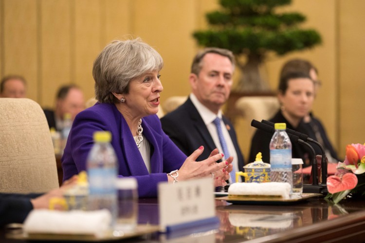 British Prime Minister Theresa May speaks as Liam Fox, U.K. international trade secretary, looks on at a bilateral meeting with China's President Xi Jinping in Beijing on Thursday.