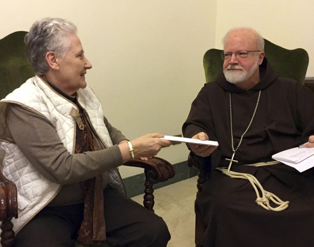 Marie Collins, part of the pope's sex-abuse commission, hands a letter in 2015 to Cardinal Sean O'Malley, Pope Francis' top adviser, about the abuse of Juan Carlos Cruz.