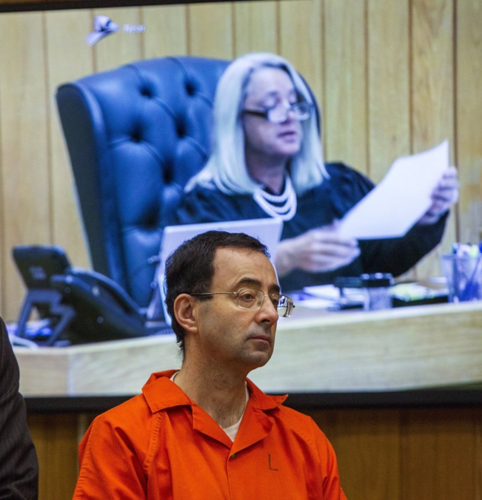 Larry Nassar listens Monday as Judge Janice Cunningham (pictured on the monitor) sentences him to 40 to 125 years for molesting young athletes at an elite Michigan gymnastics club.