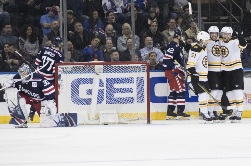 Rangers goaltender Henrik Lundqvist gets up as Bruins center Tim Schaller, second from right, celebrates his goal during the second period Wednesday night in New York.