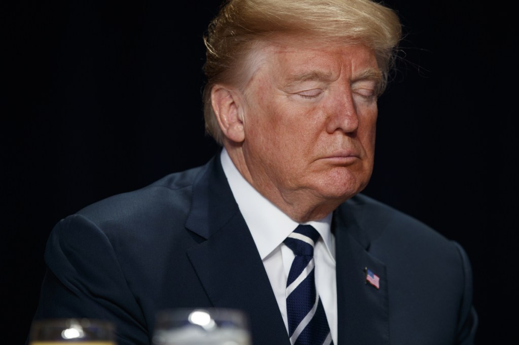 President Trump closes his eyes during the National Prayer Breakfast on Thursday in Washington. His speech to the annual gathering focused on inspiring stories of people with faith.