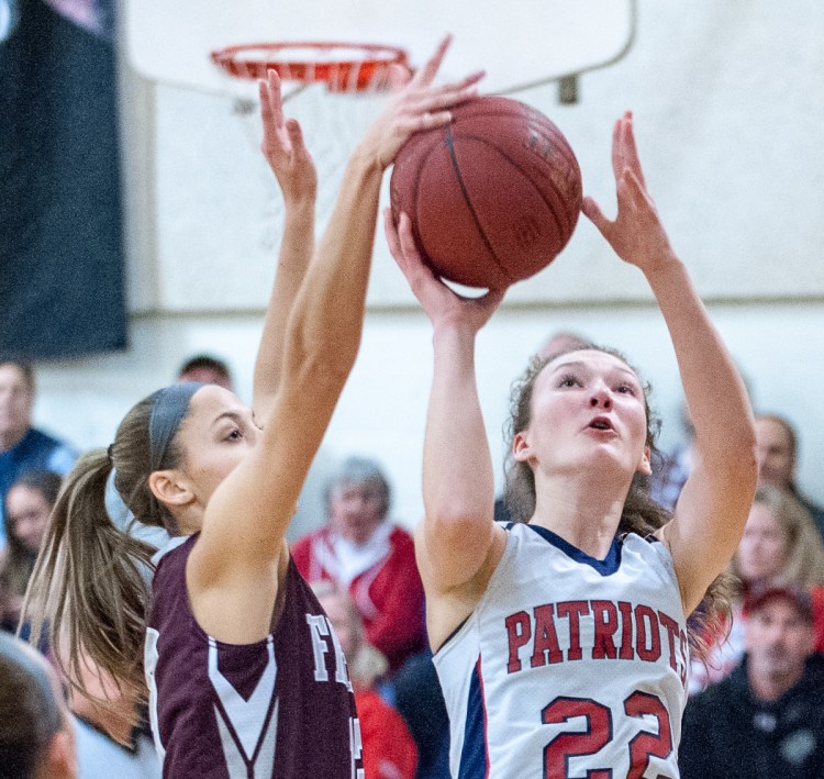Megan Cormier of Freeport blocks a shot by Gray-New Gloucester's Jordan Grant, who finished with 26 points to lead the Patriots to a 52-43 win Thursday night. (Russ Dillingham/Sun Journal)