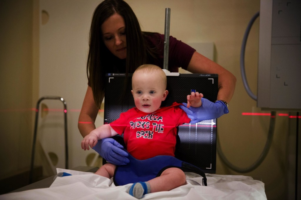 Kilian Daugherty, 1, is prepped for a chest X-ray by radiology technologist Kerah Adams while he's examined for flu symptoms at Upson Regional Medical Center in Thomaston, Ga., on Friday, as the flu further tightens its grip on the U.S.