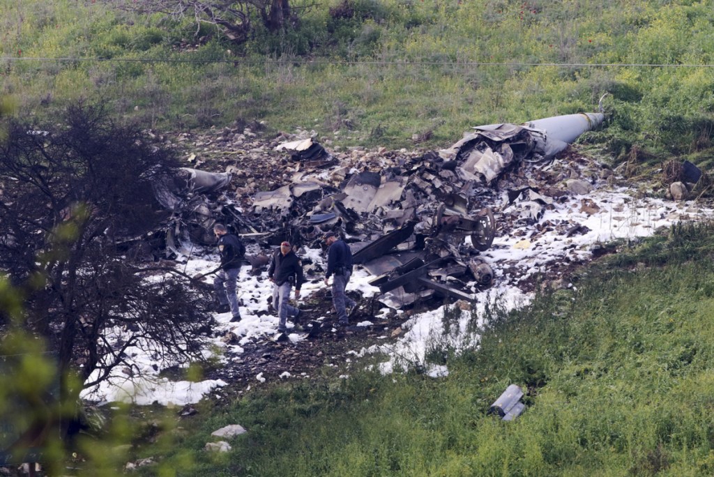 Israeli security personnel stand around the wreckage of an F-16 that crashed in northern Israel on Saturday. The Israeli military shot down an Iranian drone it said infiltrated the country early Saturday before launching a "large-scale attack" on at least a dozen Iranian and Syrian targets inside Syria, in its most significant engagement since the fighting in Syria began in 2011. Responding anti-aircraft fire led to the downing of the Israeli fighter plane.