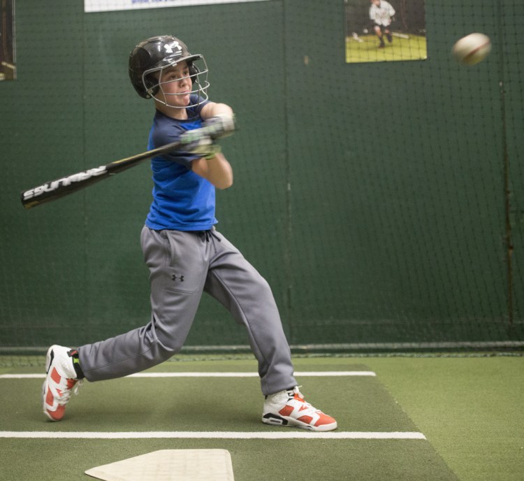 Thomas Lewis, 12, hits in the batting cage at the Westbrook Community Center during practice with his Little League team, which is using the new baseball bats mandated for youth baseball leagues.