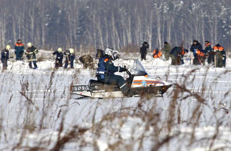 Russian Emergency Situations Ministry employees and Russian police officers work at the scene of a AN-148 plane crash in Stepanovskoye village, about 25 miles from the Domodedovo airport in Russia on Monday. A Russian passenger plane carrying 71 people crashed Sunday near Moscow, killing everyone aboard shortly after the jet took off from one of the city's airports.