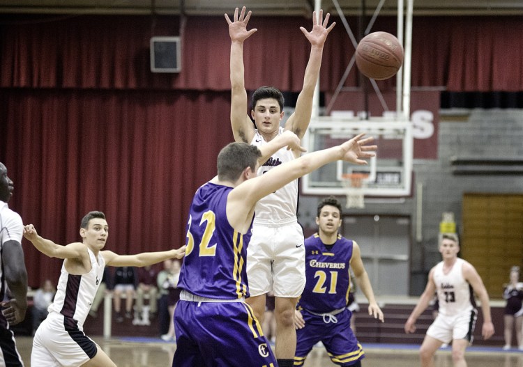 Edward Little's Tyler Morin jumps to defended a pass by Cheverus' Nick Galli during the Eddies' 59-47 win Tuesday.