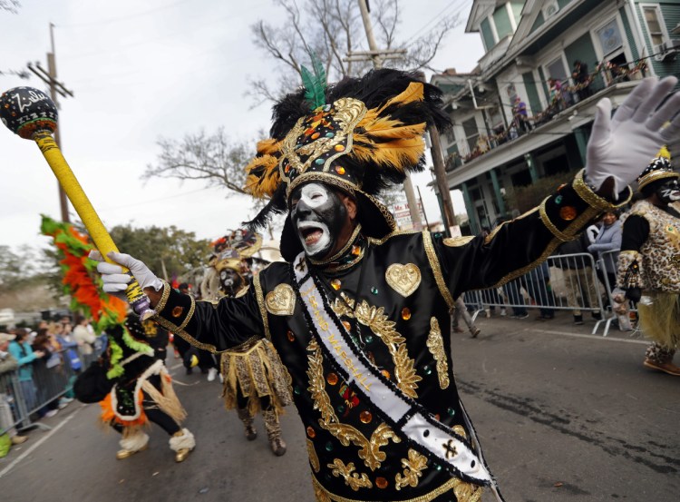 A member of the Krewe of Zulu marches during Mardi Gras parade day in New Orleans, Tuesday.