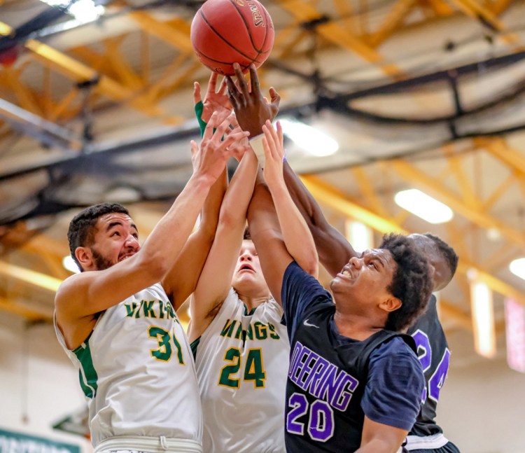 Oxford Hills' Atreyu Keniston, left, and Janek Luksza battle for a rebound with Deering's Darryl Germain, front, and Ben Onek in Wednesday night's Class AA North quarterfinal at Paris.
