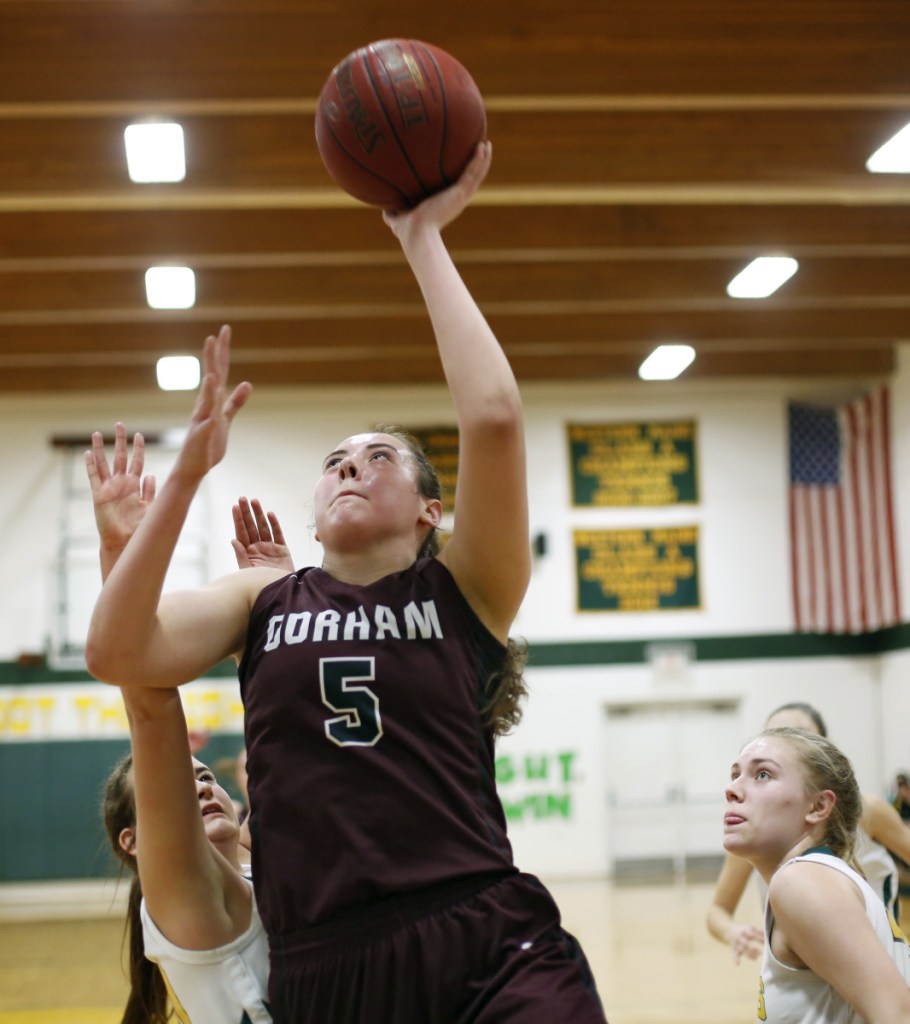 Mackenzie Holmes, who scored 21 points Thursday for Gorham, finds room between Madison Legassey, left, and Katie Fitzpatrick of Maine Girls' Academy.