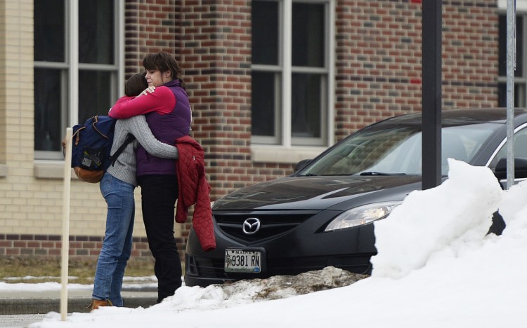 Robin Davis hugs her daughter Caroline, a sophomore, as she picks her up Thursday at South Portland High School. Earlier in the day, a 15-year-old student on his way to school was arrested on a charge of terrorizing after allegedly posting a social media message about "shooting up the school."