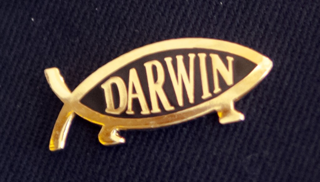 Tom Waddell of Litchfield wore a Darwin pin, shown here, and other atheist symbols on his coat while delivering the opening invocation Thursday in the Senate chamber.
