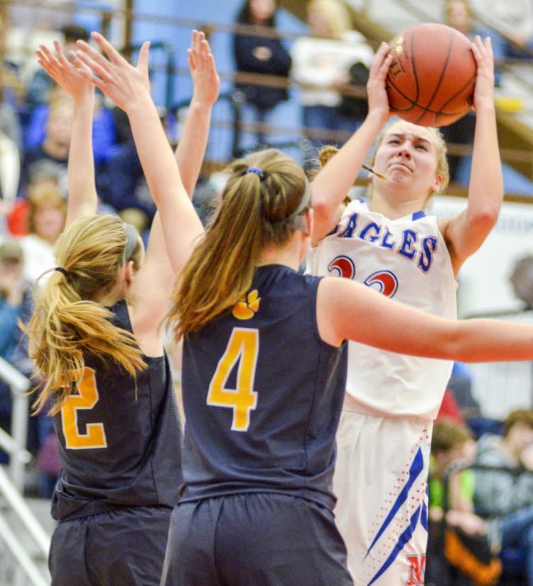 Ally Turner of Messalonskee, right, looks for room while guarded by Cheyenne Nash, left, and Aubrey Schaeffer of Medomak Valley during Messalonskee's 63-49 victory Friday in a Class A North quarterfinal at the Augusta Civic Center.