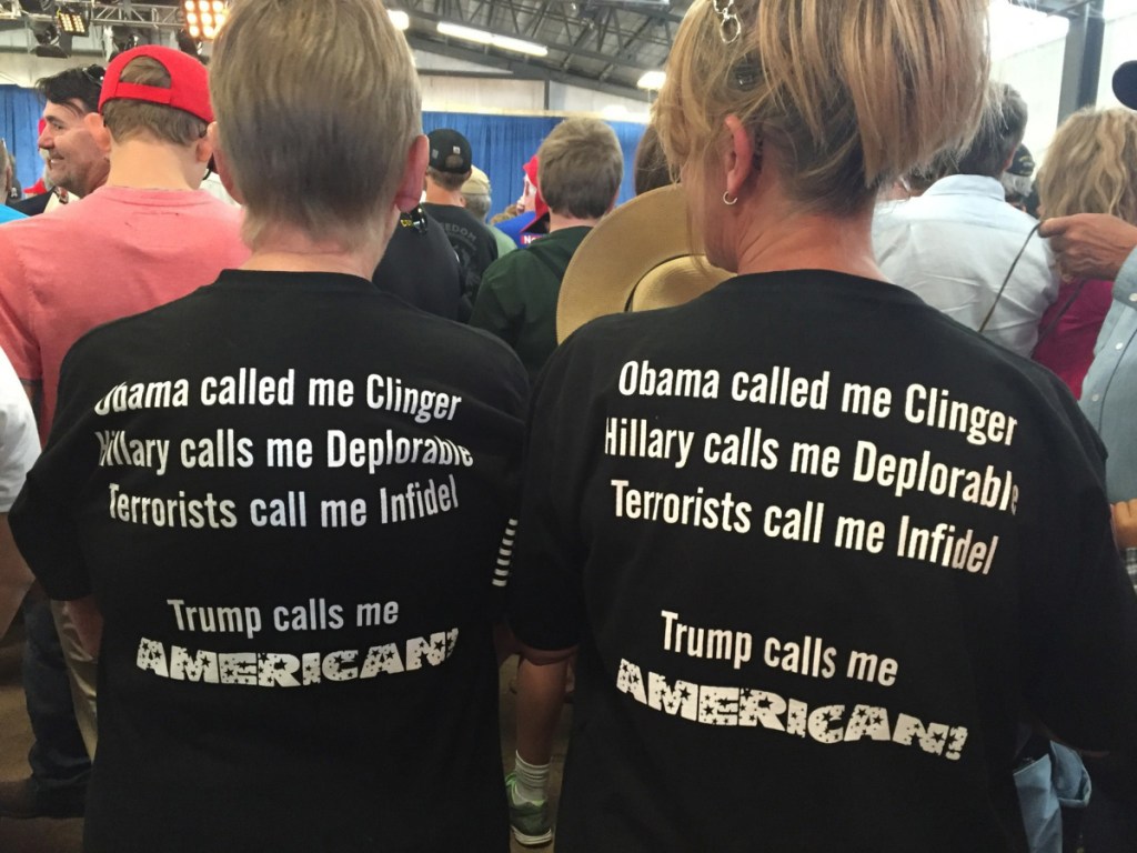 Neighbors Kathy Smith and Tina Griffiths wear matching shirts at a Trump rally in Golden, Colo., in 2016. An ideological imbalance on campus has led to national political divisions, a writer says.