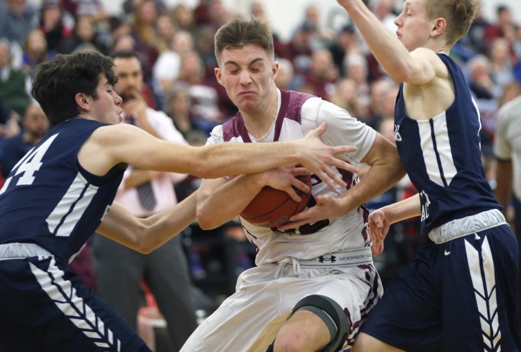 Greely's Shane DeWolfe gets tied up by Caleb Bowles, left, and Nate Knapp of Fryeburg Academy during their Class A South boys' basketball quarterfinal Friday at the Portland Expo. Top-ranked Greely won, 68-53.