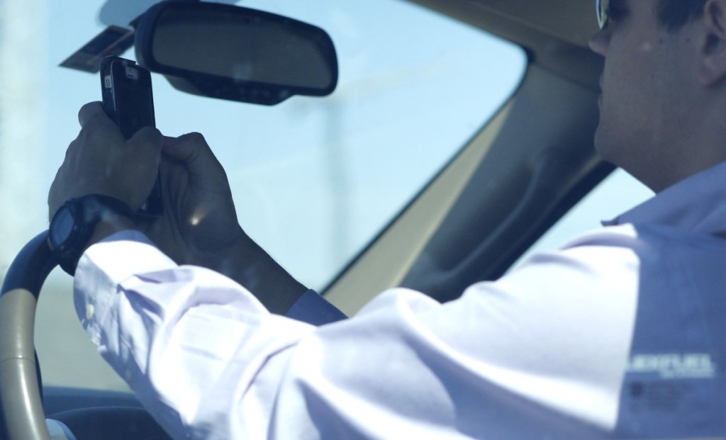 A man looks at his phone while driving down Woodall Rodgers Freeway in Dallas, Texas, in 2015.
