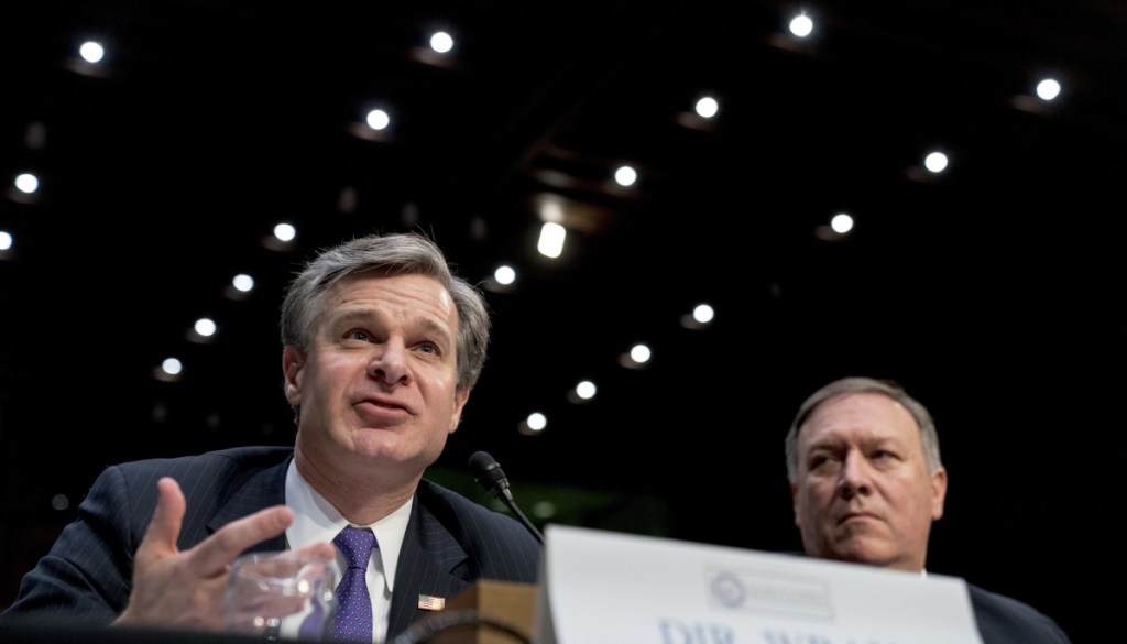 FBI Director Christopher Wray, accompanied by CIA Director Mike Pompeo, right, speaks at a committee hearing in Washington.