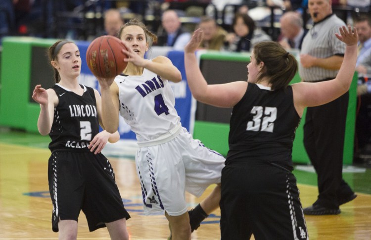 Marshwood guard Nathalie Clavette drives past Lincoln Academy's Alison York, left, and Isabelle Sawyer during a girls' basketball Class A South quarterfinal at the Portland Expo on Monday. 