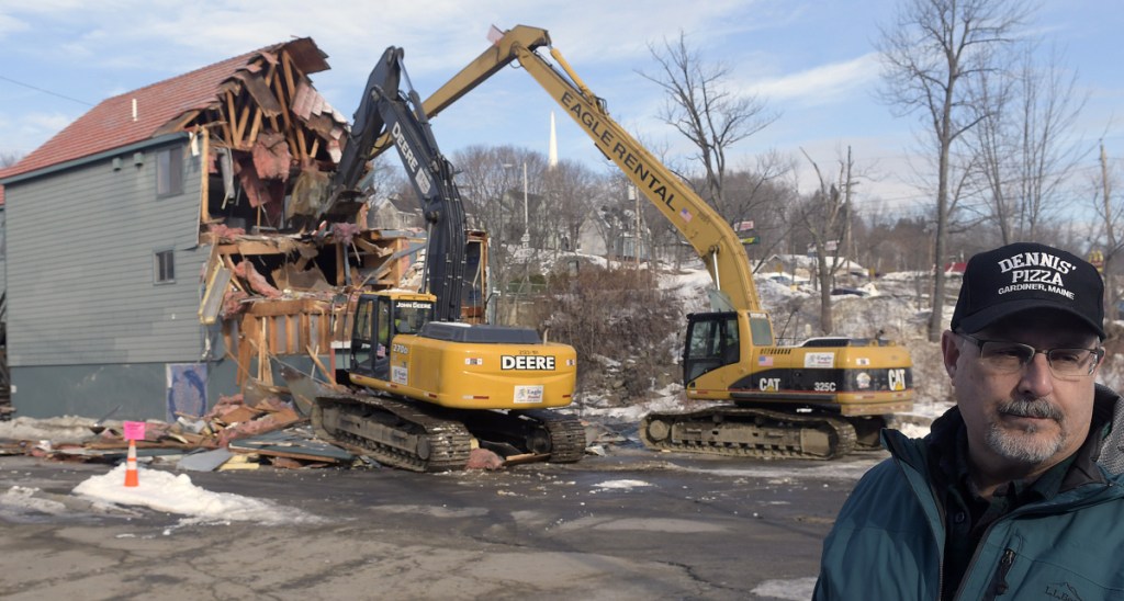Dennis Wheelock watches demolition crews raze his former business, Dennis' Pizza, in Gardiner on Monday. "Thirty years to build it; one day for it to come down," Wheelock said.