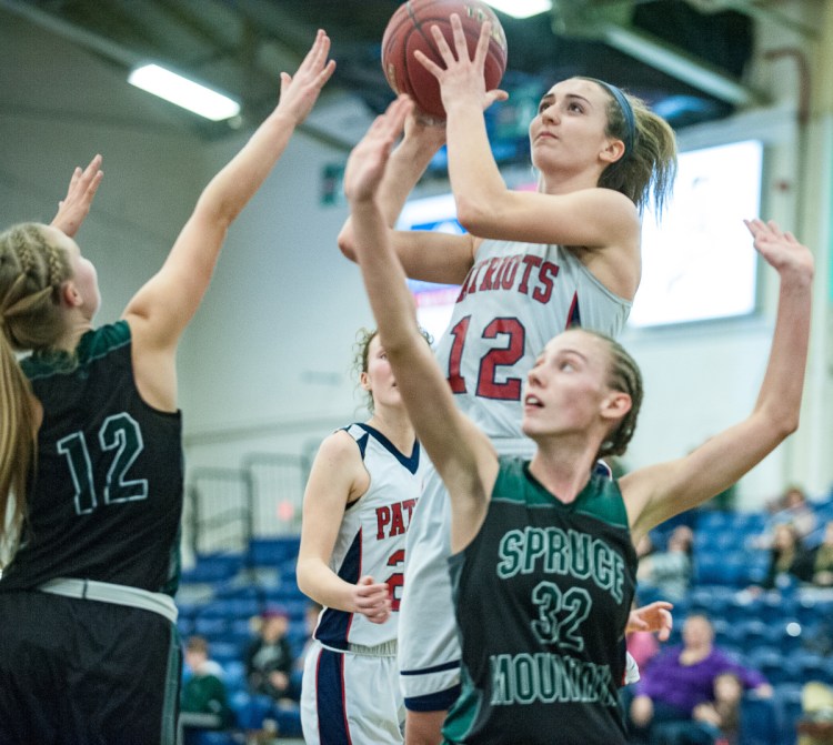 Bri Jordan drives to the basket over Spruce Mountain's Calley Baker, right and Morgan Dalton during Tuesday's 49-34 victory. The Patriots outscored the Phoenix 26-16 in the second half.