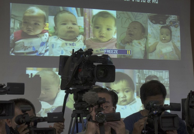 Thai police display pictures in 2014 of babies born to a Japanese man through surrogacy.