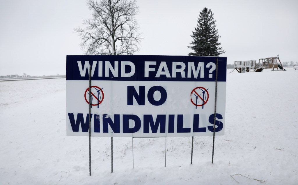 An anti-wind turbine sign stands in the front yard of a farmhouse on Jan. 24 in Glenville, Minn. Opponents of wind power are successfully stalling or rejecting wind-farm projects across the country.