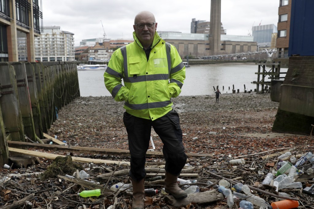Michael Byrne, a "data gatherer," stands amid plastic bottles and other debris Friday that had washed up on the bank of the River Thames in London.