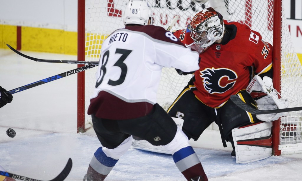 Jon Gillies, a goalie from South Portland recently called up by the Calgary Flames, turns aside a shot by Matt Nieto of the Colorado Avalanche during Calgary's 5-1 victory Saturday.