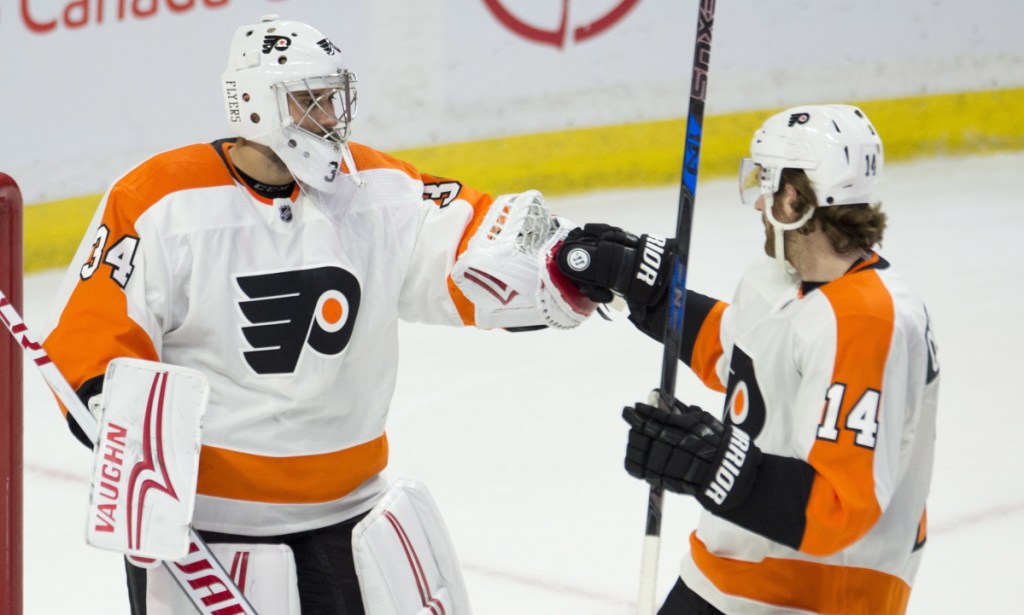 Goaltender Petr Mrazek, left, and Sean Couturier of Philadelphia celebrate Saturday after a 5-3 victory against the Ottawa Senators. It was Mrzek's second game with the Flyers.