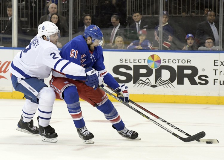 Toronto defenseman Ron Hainsey checks New York right wing Rick Nash as he controls the puck. The Rangers traded Nash as part of a multiplayer deal with the Bruins. New York acquired the Bruins' first-round pick in this year's draft as well as forwards Ryan Spooner and Matt Beleskey and a seventh-round pick in the 2019 draft.
