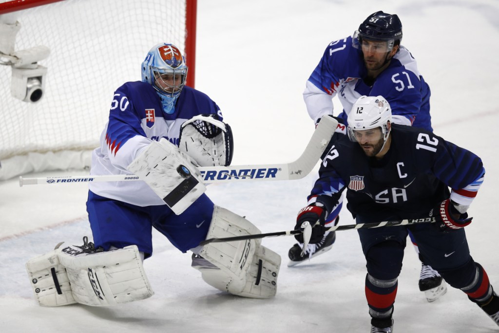 U.S. goalie Ryan Zapolski deflects a shot as Brian Gionta and Dominik Granak of Slovakia battle for position. Gionta will return to Boston, where he spent four years at Boston College.