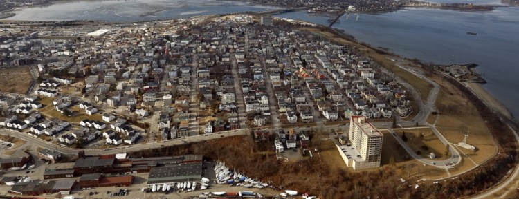 An aerial view of Munjoy Hill. The tower in the foreground is the Portland House and Fort Allen Park is at bottom right. Tukey's Bridge, which carries I-295 over Back Cove, and a disused railroad bridge are in the distance at top center.