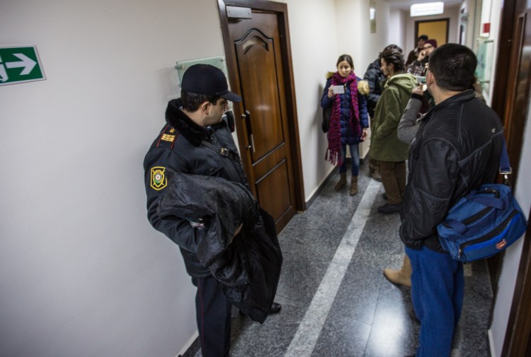 A police officer stands guard as journalists gather at Radio Free Europe's Azerbaijan bureau on Dec. 26, 2014, the day officials raided and closed the bureau. The U.S. has failed to hold the authoritarian nation accountable for its human rights violations.