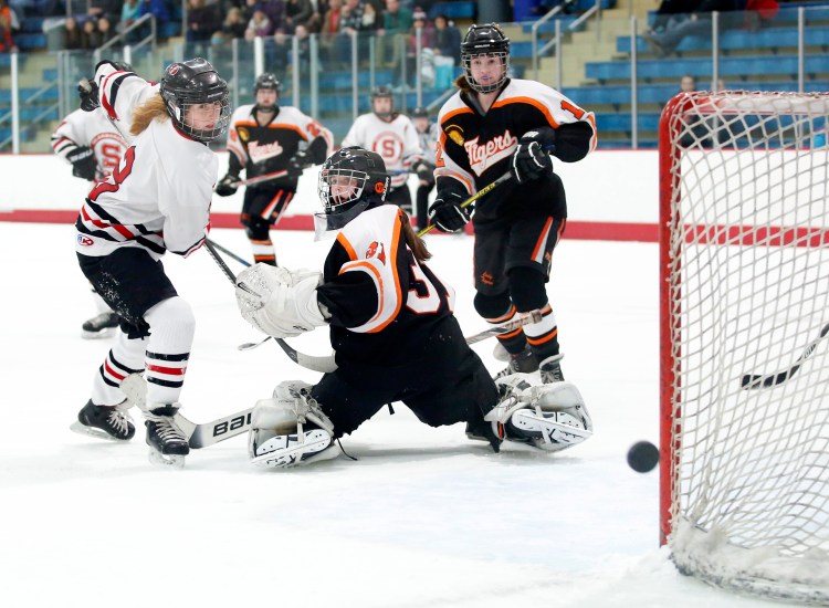Carrie Timpson of Scarborough watches her shot narrowly miss the goal after tipping it over the shoulder of Biddeford goalie Trinity Atwater in the second period.
