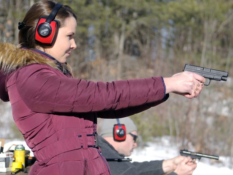 Katherine Pollock fires a pistol with Rob Sibley on Jan. 6, 2016, at the Department of Inland Fisheries & Wildlife range in Augusta.