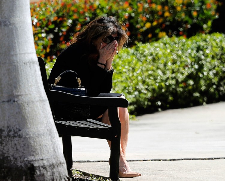 A woman weeps as she sits outside the Temple K'ol Tikvah before the funeral of Meadow Pollack, a victim of the Wednesday shooting at Marjory Stoneman Douglas High School, in Parkland, Fla., on Friday. Nikolas Cruz, a former student, was charged with 17 counts of premeditated murder. 