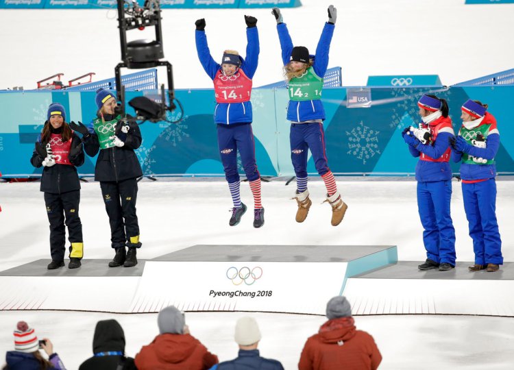 Gold medalists Kikkan Randall and Jessica Diggins of the United States are  flanked by silver winners Stina Nilsson and Charlotte Kalla of Sweden, left, and bronze medalists Marit Bjoergen and Maiken Caspersen Falla of Norway after the women's team sprint freestyle cross-country  final at the 2018 Winter Olympics.